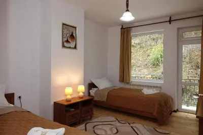 a bedroom with two beds and a window at Семеен хотел Орфей in Teshel