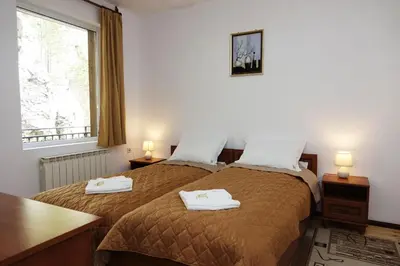 a bedroom with two beds with towels on them at Семеен хотел Орфей in Teshel