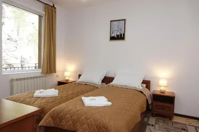 a bedroom with two beds with towels on them at Семеен хотел Орфей in Teshel