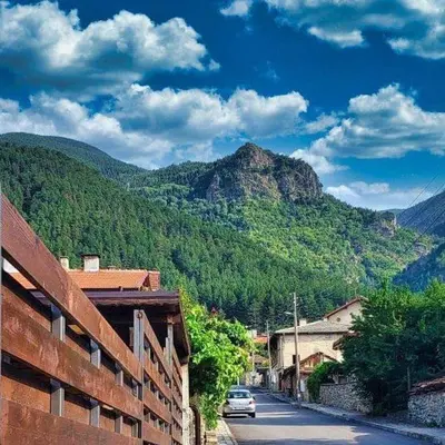 a car driving down a street with a mountain at Къща за гости “Приятели“ in Ovchartsi