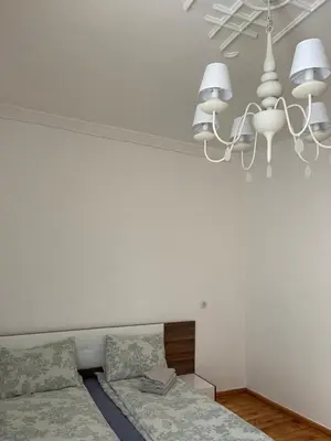 a white room with a bed and a chandelier at Parchevich 26 Apartment - 24h Self Check-in in Sofia