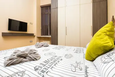 a bed with a comforter and towels on it at 1BD Apartment with a Cute Balcony in Kapana by Flat Mаnager in Plovdiv