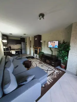 a living room with couches and a flat screen tv at Green Life, Bansko, private property in the complex Paradiso Verde, apartman C23 in Bansko