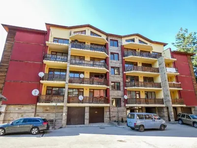 a large building with cars parked in a parking lot at Borovets Sequoia2 Apartment no 5 in Borovets