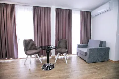 a living room with a couch and a table and chairs at Apartments Monik Sandanski in Sandanski
