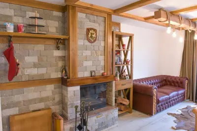 a living room with a brick fireplace and a couch at Лукс апартамент in Bansko