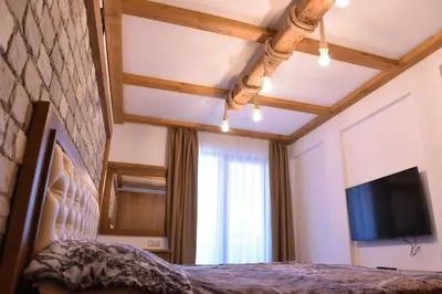 a bedroom with a bed and a flat screen tv at Лукс апартамент in Bansko
