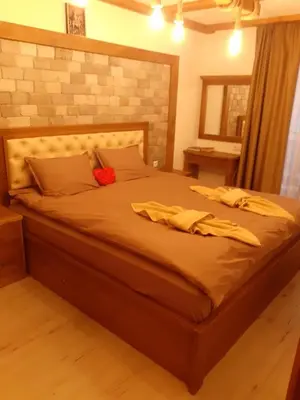 a bedroom with a large bed with a red flower on it at Лукс апартамент in Bansko