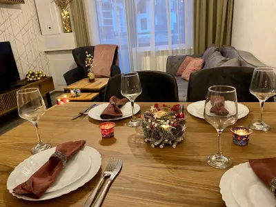 a wooden table with plates and wine glasses on it at Luxury Aparthotel STUDENETS in Pamporovo