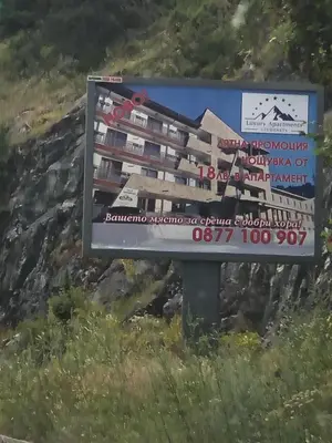 a sign for a hotel on the side of a mountain at Luxury Aparthotel STUDENETS in Pamporovo
