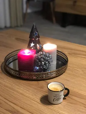 a tray with candles and a cup of coffee on a table at Luxury Aparthotel STUDENETS in Pamporovo