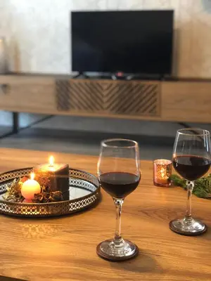 two glasses of wine and a piece of cake on a table at Luxury Aparthotel STUDENETS in Pamporovo