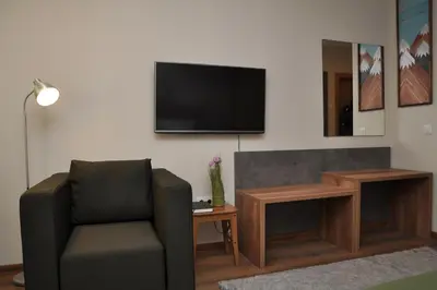 a living room with a chair and a flat screen tv at Hashtag Studio Borovets in Borovets