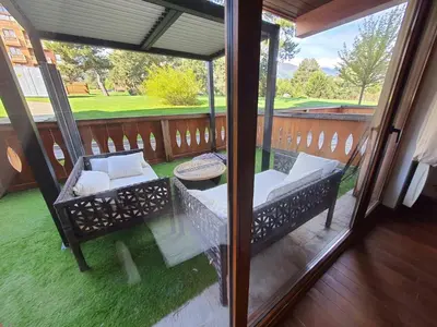 a porch with two chairs and a table on a balcony at Vintage studio at Pirin golf in Bansko