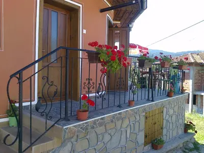 a balcony with potted plants on a wall at Тороманова къща in Koprivshtitsa