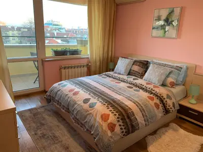a bedroom with a bed and a large window at Central and Spacious apartment in Sofia