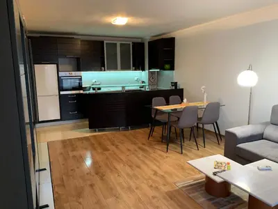 a living room and kitchen with a couch and a table at Central and Spacious apartment in Sofia