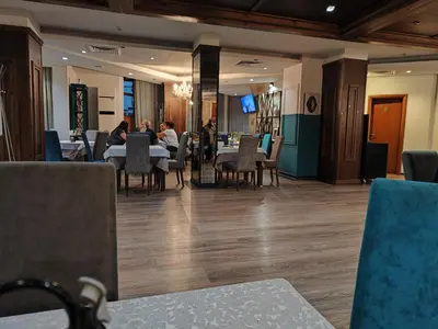a restaurant with people sitting at tables and chairs at Bansko Belvedere Apartament in Bansko