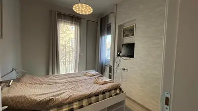 a bedroom with a bed and a tv and a window at Top Central Place with 2 bedrooms in Sofia in Sofia