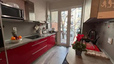 a kitchen with red cabinets and a sink and a window at Top Central Place with 2 bedrooms in Sofia in Sofia