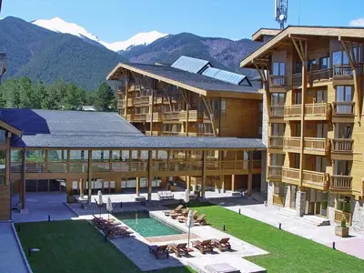 a large building with a swimming pool and a resort at Pirin Golf Hotel Private Studios in Razlog