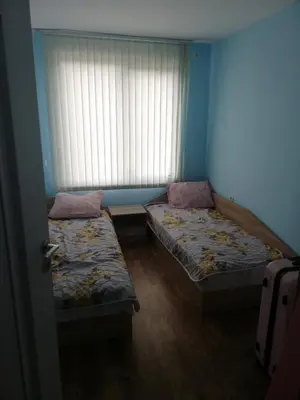 two beds in a room with a window at Стаи за гости РИЛА in Rila