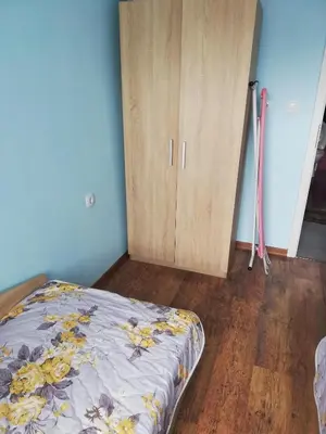 a bedroom with a bed and a wooden cabinet at Стаи за гости РИЛА in Rila