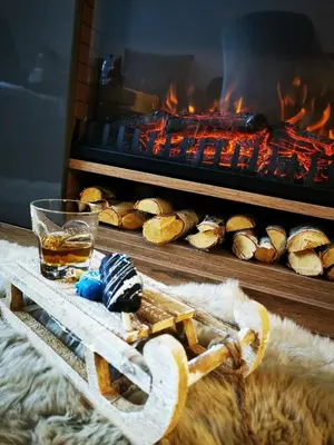 a fireplace with bread and a glass of whiskey next to a fireplace at Mountain Paradise in Aparthotel Borovets Gardens in Borovets