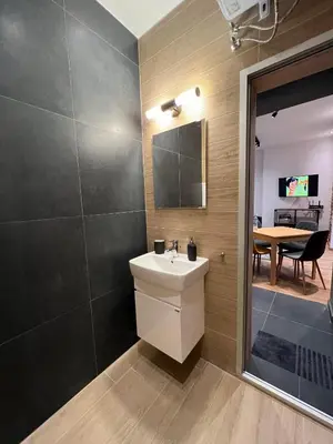 a bathroom with a sink and a mirror and a table at HOME 12 in Sofia