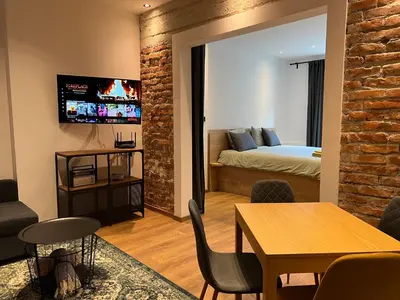 a living room with a bed and a dining room at HOME 12 in Sofia