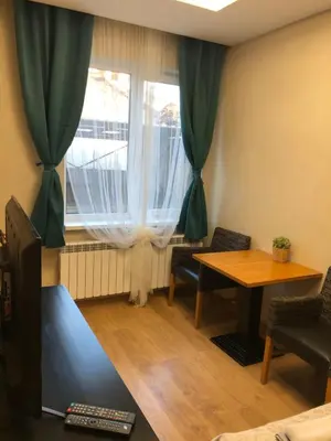 a living room with a table and a window at APARTHOTEL BON BON in Sofia