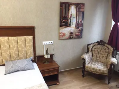 a bedroom with a bed and a chair and a mirror at APARTHOTEL BON BON in Sofia