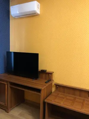 a room with a tv on a wooden table with a desk sidx sidx at APARTHOTEL BON BON in Sofia