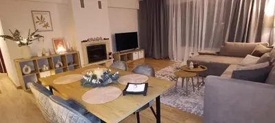a living room with a table and chairs and a couch at Free SPA Pirin lodge cosy apartment in Bansko