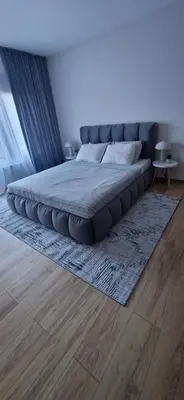 a large bed in a bedroom with a rug at Free SPA Pirin lodge cosy apartment in Bansko