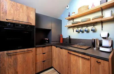 a kitchen with wooden cabinets and a black appliance at KOKICHE 4 Friends, Borovets in Borovets