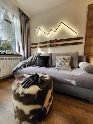 a living room with a couch and a ottoman at Pinewood ANG luxurious apartment A43, Borovets Gardens in Borovets
