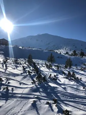 a snow covered slope with the sun in the sky at BREATHTAKING Mountain view 3 bedrooms appartement in Bansko