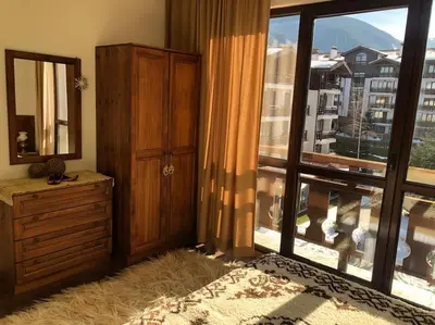 a bedroom with a dresser and a large window at BREATHTAKING Mountain view 3 bedrooms appartement in Bansko