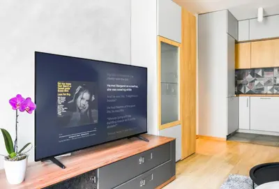 a flat screen tv sitting on a stand in a living room at Downtown - Netflix - AC - Next to Metro and Train in Sofia