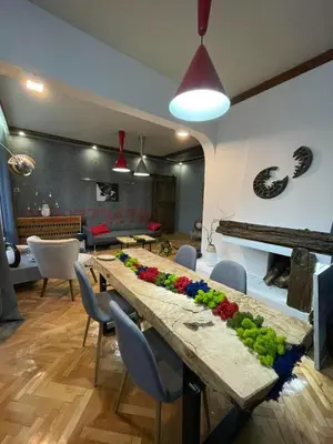 a large wooden table with flowers on it in a living room at Top center Art deluxe apartment near to Aleksander Nevsky cathedral in Sofia