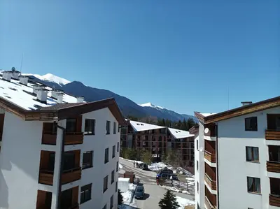 a view from the balcony of a hotel with snow covered mountains at Studio Detelina Residence in Bansko