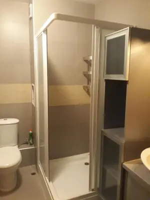 a bathroom with a shower with a toilet and a sink at Studio Detelina Residence in Bansko