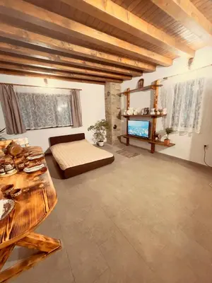 a large room with a bed and a table at Къща за гости На Мечка in Oborishte