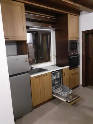 a kitchen with a white refrigerator and a dishwasher at Къща за гости На Мечка in Oborishte
