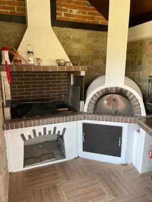a brick oven with a tv in a room at Къща за гости На Мечка in Oborishte