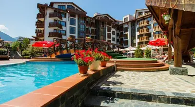 a hotel swimming pool with potted plants and buildings at Belvedere Holiday Club 101 in Bansko