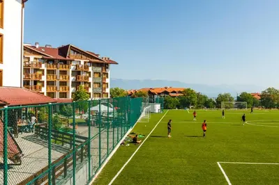 a group of people playing soccer on a soccer field at Belvedere Holiday Club 101 in Bansko