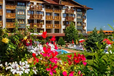 a hotel with flowers in front of a building at Belvedere Holiday Club 101 in Bansko