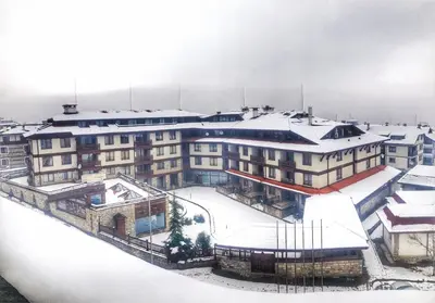 a large building with snow on top of it at Bellevue Residence RELAX ZONE in Bansko